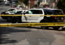 Wrong-Way Crash Leads To Two Murder Charges Police tape cordoning off street with patrol SUVs behind