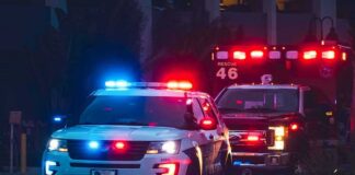 Police SUV and ambulance with flashing lights at night