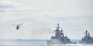military ships and helicopter at sea
