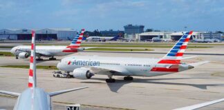 American Airlines jets taxi at a busy airport apron