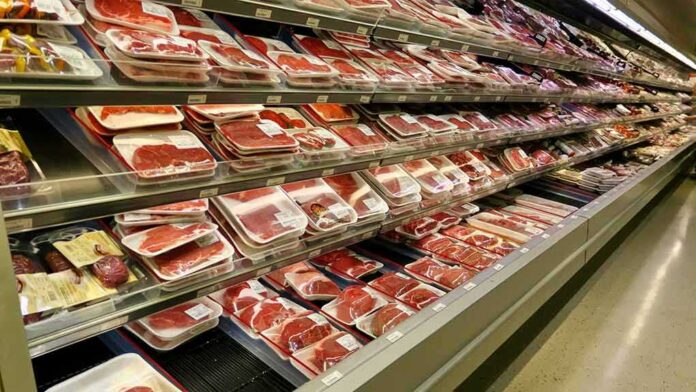 supermarket meat section with packaged cuts in refrigerated shelves