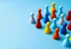 Pro-LGBT Image Vs. Ugly Allegations Colorful board game pawns grouped on a blue surface