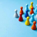Pro-LGBT Image Vs. Ugly Allegations Colorful board game pawns grouped on a blue surface