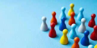 Colorful board game pawns grouped on a blue surface