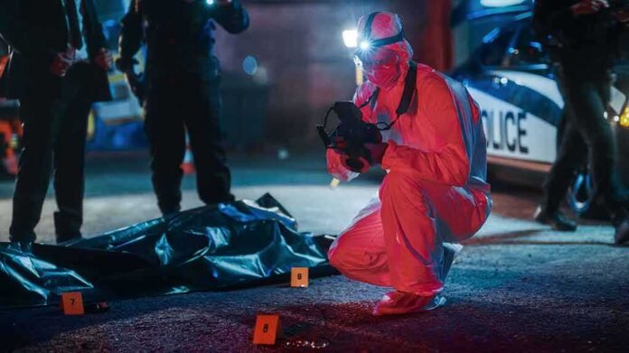 shutterstock_2230645973 forensic investigator photographs crime scene evidence at night