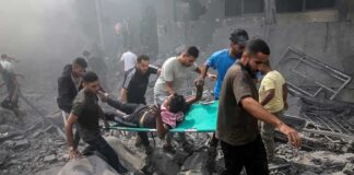 Rescuers carry an injured person on a stretcher through rubble