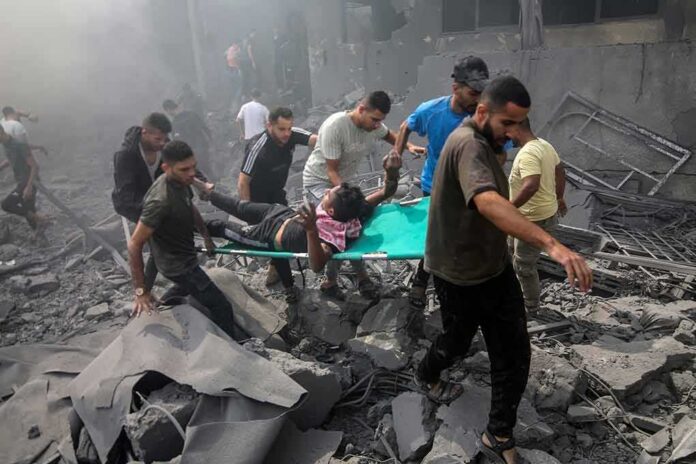 Rescuers carry an injured person on a stretcher through rubble