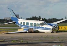 Governor Hopeful’s Plane Drops Into Lake Damaged blue and white small airplane on an airport runway