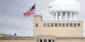 Water treatment plant with US flag and large white water tower