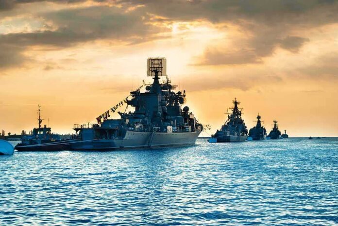shutterstock_380863549 Naval warships anchored in a harbor at sunset