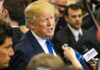 Trump’s Live Text Upends Maher Claim man in suit speaking to reporters with microphones