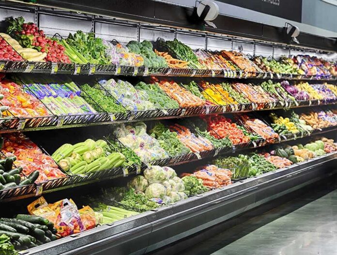Grocery store produce aisle with stacked fresh vegetables
