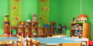 Preschool classroom with small tables and wooden chairs