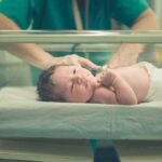Baby Tug-Of-War Explodes In Texas Newborn baby in hospital bassinet being cared for by nurse