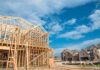 Wood-framed house under construction in a suburban neighborhood
