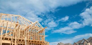 Wood-framed house under construction in a suburban neighborhood
