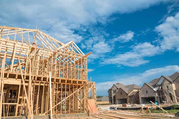 Wood-framed house under construction in a suburban neighborhood