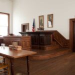 Shocking Bolton Leak Plea Stuns D.C. Interior of a historic courtroom with wooden furniture and an American flag