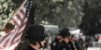 police officer in riot gear standing in a line