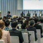 Bill Kenney at a conference panel with an audience