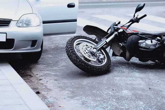 Motorcycle lying on the street beside a car with an open door
