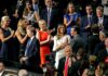 Biden-Era FBI Tracked Trump Family Travel Tiffany Trump, Melania Trump, and Donald Trump Jr. among a crowd applauding at an event