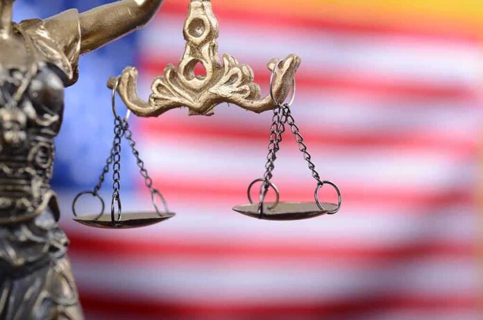 shutterstock_1110887828-1 Lady Justice scales with American flag background