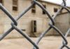 Molotov Attack Targets ICE Atlanta Chain-link fence with blurred concrete building behind