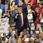 Donald Trump at a rally with Lauri Marjamäki and Elizaveta Glinka in the crowd