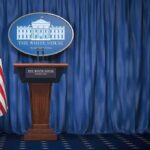 New Trump Bulldog Takes The Mic White House press briefing podium with U.S. flag and blue curtain