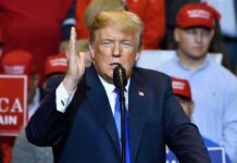 Trump Praises Musk, Slams Governor Donald Trump speaking at a rally with supporters in the background