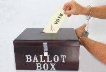 Late-Night Power Play Targets Votes Hand in handcuffs casting a vote into a ballot box