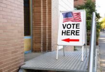 General Says Military Won’t Touch Ballots Sidewalk sign with American flag directing to a polling place