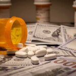Refund Shock: HealthCare.gov Cash Back Prescription pill bottle and white tablets on scattered US dollar bills