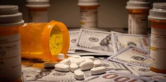 Prescription pill bottle and white tablets on scattered US dollar bills