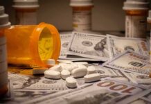 Prescription pill bottle and white tablets on scattered US dollar bills