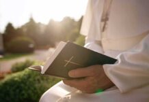 Vatican Rush: Pope Heads Into Surgery Person in white robe holding a Bible outdoors