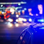 Stadium Panic Triggers Multi-City Manhunt Police car with flashing blue lights at night