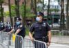 Walter Jones, a police officer in a face mask standing by metal barricades