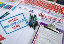 Socialism Smear Backfires – Poll Shock Voter registration table with forms, pens, and informational materials