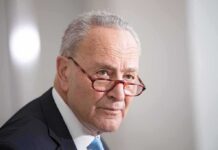 Schumer Puts Tariffs At Center Of Debate older man in suit with red glasses looking to the side