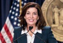 Gov Hochul Torches Minaj – Intense Feud woman speaking at a podium with microphones