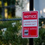 Police Dragnet Nails Wrong Driver? Red notice sign on a black pole in a leafy outdoor area