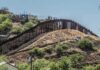 Border fence running over a hilly landscape