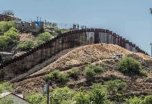 Border fence running over a hilly landscape