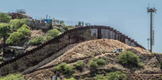 Border fence running over a hilly landscape