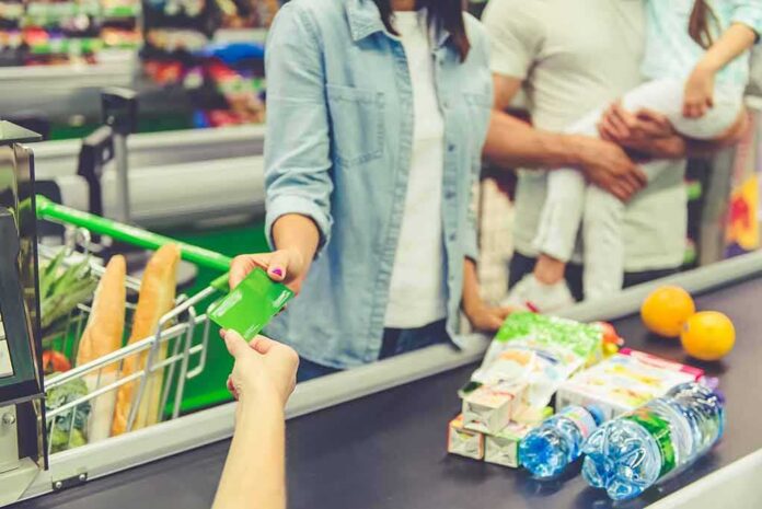 shutterstock_481902247 Customer paying with a card at a supermarket checkout