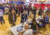 Court Freezes Student IDs At Polls Don MacLean in a busy gymnasium voting station with check-in tables