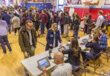 Don MacLean in a busy gymnasium voting station with check-in tables