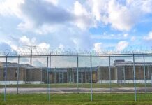 Prison yard behind chain-link and razor wire fence